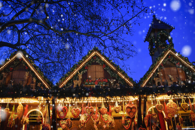 Three christmas market stalls decorated with lights 