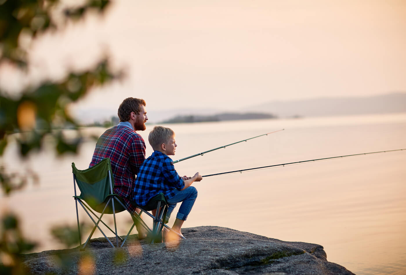 father and son fishing alongside a lake