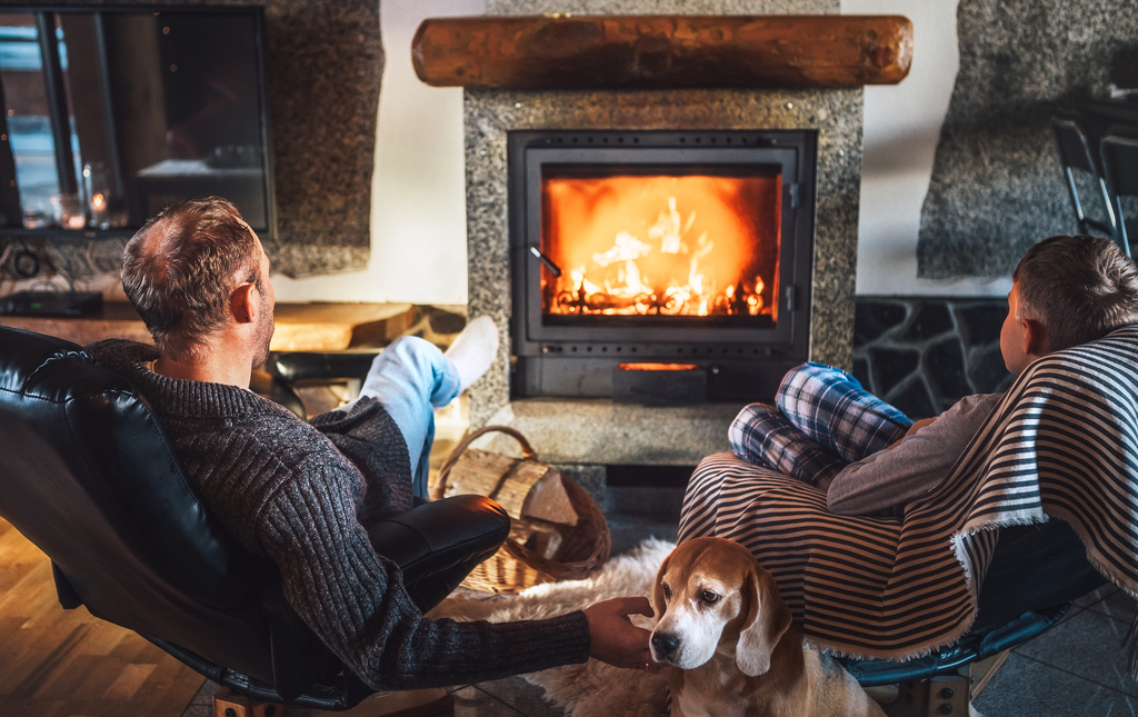 Couple and dog sat in front of fireplace