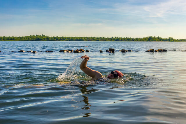 A woman open water swimming in a lake