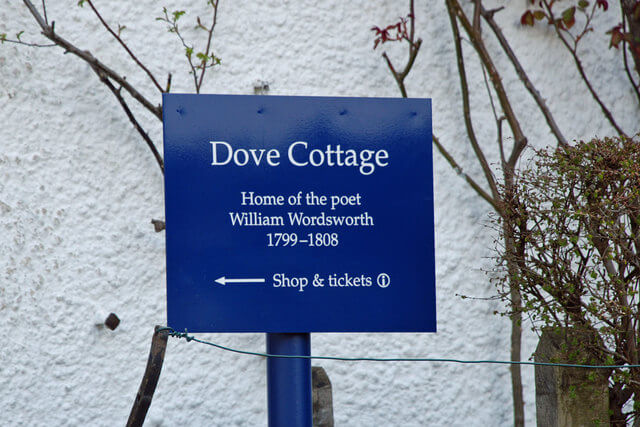 A blue sign directing to Dove Cottage in Grasmere