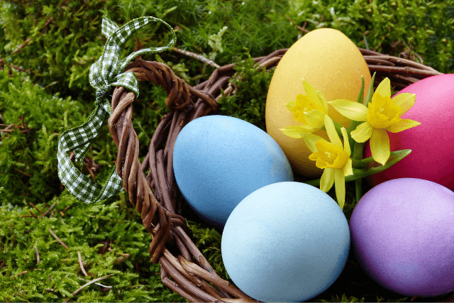 Easter eggs in a basket in a green field.