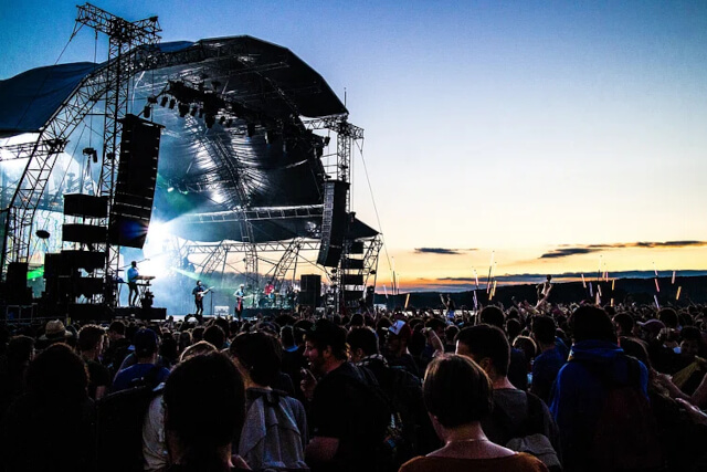 Festival goers stood outside a music stage at a festival