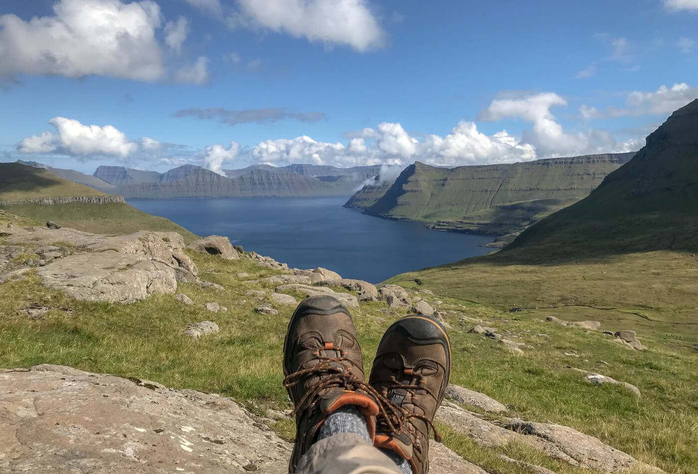 A pair of walking boots with a lake and mountains in the distance