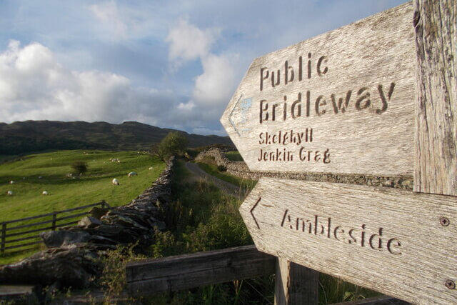 A wooden signpost pointing to Ambleside and Jenkin Crag