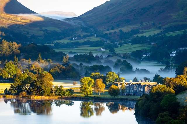Misty sunrise across Grasmere in the Lake District.